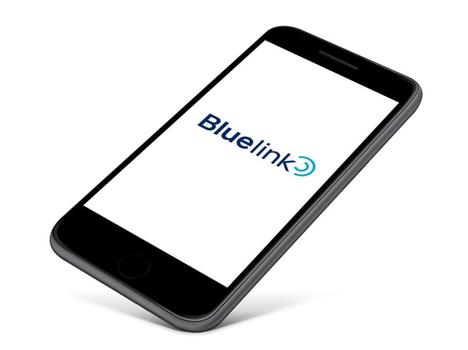 A smartphone with the Hyundai Bluelink logo visible on the screen.