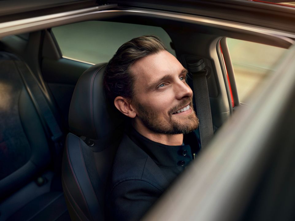 Man in the passenger seat of his Hyundai i30 Fastback, seen through the open sunroof.
